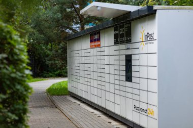 Wroclaw, Poland- 13 Eylül 2025: yeşil park alanında bulunan modern paket dolabı. Modern lojistik, çevrimiçi alışveriş, dağıtım teknolojisi ve ulaşılamayan hizmet