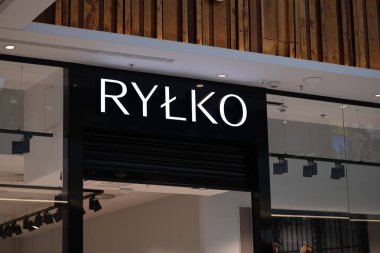 Wroclaw, Poland- 25 Ekim 2025: Rylko mağazasının önde gelen logosu ve simgesi, üzerinde ahşap tavan elementi olan modern bir alışveriş merkezinin parlak, koyu bir cephesinde.