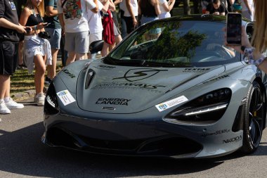 Wroclaw, Polonya - 21 Haziran 2025: Gri renkli McLaren 720S supercar halka açık bir etkinlikte park edilmiş ve arka plandaki atmosferin tadını çıkaran izleyiciler
