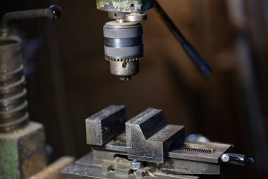 Profesyonel bir matkabı çelik fırlatma ve metal mengeneyle kapat. Endüstriyel metal işleme ekipmanları, hassas sondaj araçları ve makine mühendisliği