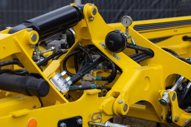 Basınç göstergesi ve metal çerçeve bileşenleriyle modern tarımsal karavan hidrolik sistemini kapatın. Tarım makineleri, ağır ekipman mühendisliği ve kırsal sanayi teknolojisi teması