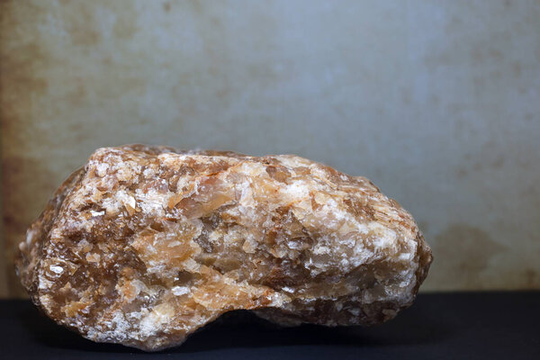 A large, raw honey calcite stone with a rich golden-brown tone and natural crystal texture.