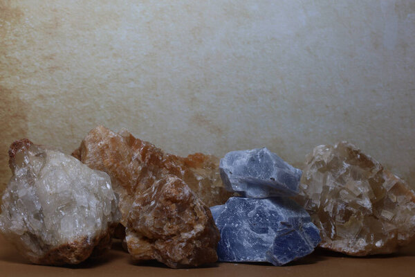 Unpolished calcite stones with earthy and cool tones, displayed together for educational and metaphysical contexts.
