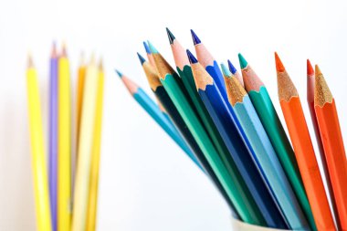 Tamamlayıcı renk karşıtlığını sembolize eden mavi ve turuncu kalemlerin ayrıntılı yakın çekimi