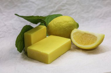 Asgari düzeyde narenciye sabunu ve taze limon, doğal bir zemin üzerinde, çevre dostu kozmetik ambalaj ve sağlıklı pazarlama için mükemmel..