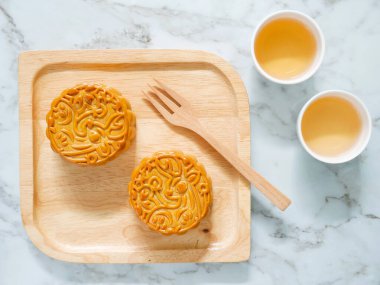 Sonbahar ortası festivali ya da ay çöreği festivali için içinde çay olan ahşap bir tabakta ay çöreği. Üst görünüm.