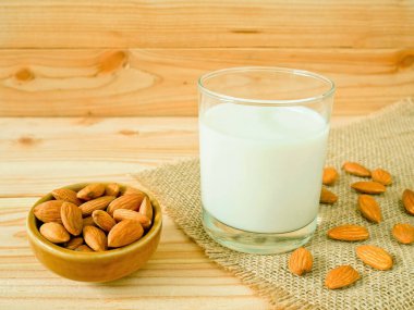 Ahşap masa üzerinde kabuklu badem ile badem süt