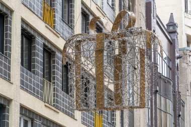 Gündüz vakti şehirde asılı duran büyük bir Noel hediyesi kutusu ışık dekoru.