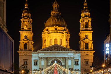 BUDAPEST, HUNGARY - 27 ARALIK. 2024: Aziz Stephen Bazilikası 'nın (Szent Istvn Bazilikası) önündeki meydanda renkli ışıklarla Noel Advent Fuarı).