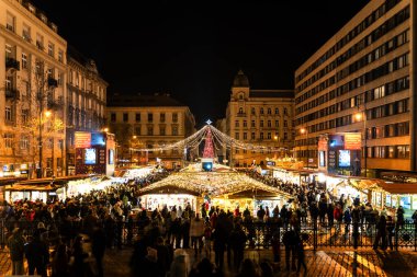 BUDAPEST, HUNGARY - 27 ARALIK. 2024: Aziz Stephen Bazilikası 'nın (Szent Istvn Bazilikası) önündeki meydanda renkli ışıklarla Noel Advent Fuarı).