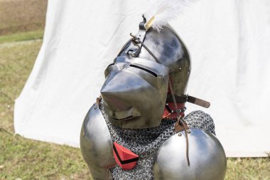 Ortaçağ zırhı göğüs zırhı ve miğferiyle ayakta duruyor.