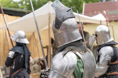 Tam zırhlı ortaçağ şövalyeleri kılıçları taşıyor.