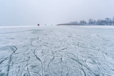 Kışın buz yüzeyinde figür olmayan paten izleri var.