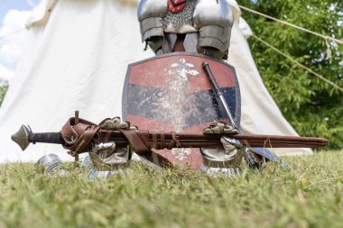 Ortaçağ kılıcı, eldivenler ve çimenlerde zırhlı kalkan.