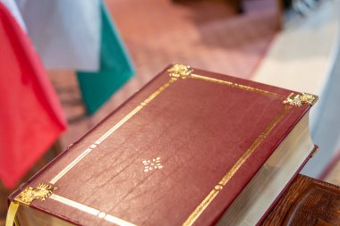 Closed antique book with gilded edges on wooden stand