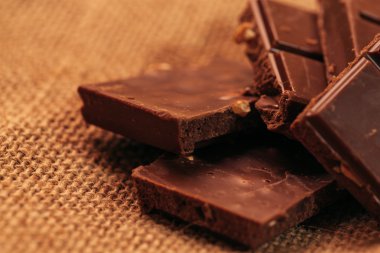 çuval bezi arka plan üzerinde koyu çikolata parçaları