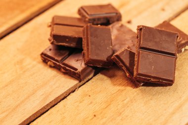 ahşap arka plan üzerinde koyu çikolata parçaları