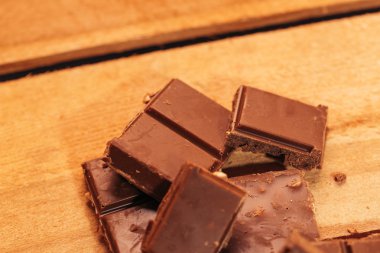 ahşap arka plan üzerinde koyu çikolata parçaları