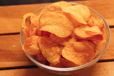 patates cipsi ahşap arka plan üzerinde kase temizleyin