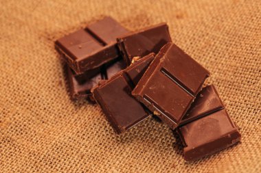 çuval bezi arka plan üzerinde koyu çikolata parçaları