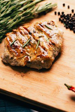 ızgara et, biberiye ve hafif ahşap bir arka plan üzerinde kırmızı acı biber fışkın