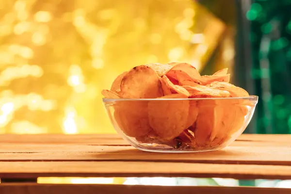 Clear bowl of potato chips on a blurred background — Stock Photo, Image