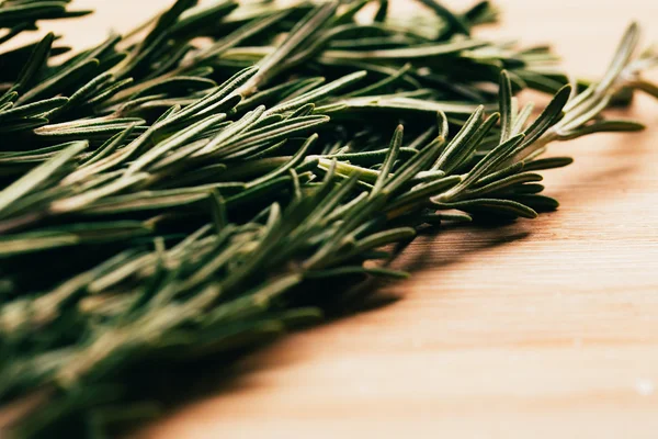 Bundle of sprigs rosemary on a wooden light background — Stock Photo, Image