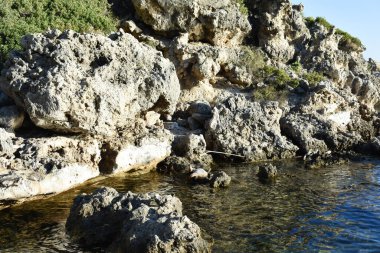 Ladiko Bay on Rhodes Island, Greece. Mediterranean Sea. Holidays in Greece. Travel to Rhodes. Summer and holidays. Rocks and water. Natural background. Greek sea and nature.