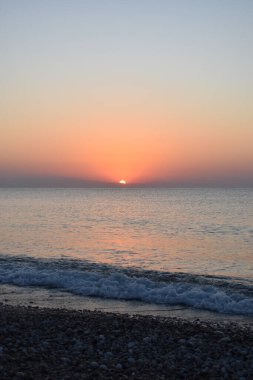 Summer sunrise sea sky landscape, Afandou village, Rhodes Island, Greece. Colorful sea beach sunrise, calm waves. Coast horizon scenic coast view. Tourism and beach holidays. Travel to Greece.