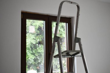 Eski metal alüminyum merdiven ve yeni bir pencere. Eski metal bir merdiveni kapat. Tadilat ve inşaat malzemeleri için. Evdeki ya da dairedeki boş oda. Ev yenileme konsepti.