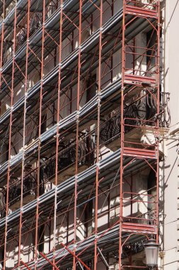 İnşaat için yapı iskelesi. İnşaat halindeki yapı iskelesi olan bir bina. İtalya 'nın Sicilya kentindeki inşaat çalışmalarına güvenli erişim için yapı iskelesi.