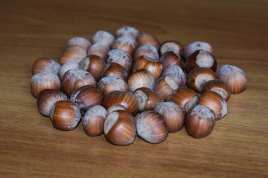 Kabuklarında taze fındıkların yakın plan görüntüsü, ahşap bir yüzeye saçılmış. Sağlıklı organik atıştırmalık. Ahşap arka planda fındık. Sağlıklı gıda ve sağlıklı beslenme konsepti.