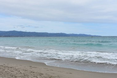 İlkbaharda Poetto plajı, Cagliari, Sardinya, İtalya. Sardegna 'da tatiller. İtalya 'ya git. Seyahat ve turizm konsepti. Akdeniz 'de. Beyaz kumlu sahil.