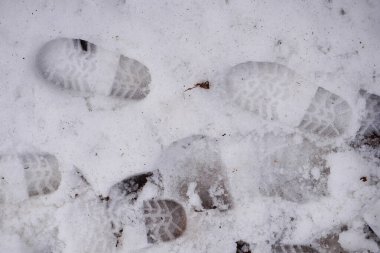 Kışın karda ayak izleri. Ayak izlerinin üst görüntüsü. Karda ayak izi var. Kış yürüyüşü. Ayakkabı izi. Kış yürüyüşü. Bir insan karda yürüdü..