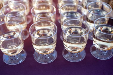 Açık bir kafedeki masada serinletici içeceklerle bir sıra bardak. Yaz tatili kavramı, bir restoranda sosyal toplantı ve Akdeniz tarzında konukseverlik..