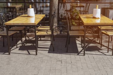 Güneşli bir günde bir rulo kağıt havlu ve peçeteyle boş bir kafeterya masası. Gündelik sokak yemekleri, restoran bakımı ve halka açık etkinlikler için organize servis alanı kavramı