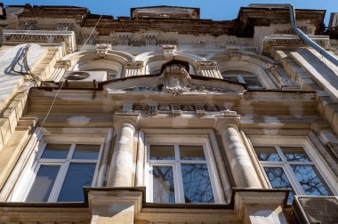 19. yüzyıldan kalma bir eklektizm binasının ön cephe tamiri gerektiren düşük açılı görüntüsü. Mimari mirasların korunması, kentsel bozulma ve tarihi şehir merkezi restorasyonu kavramı