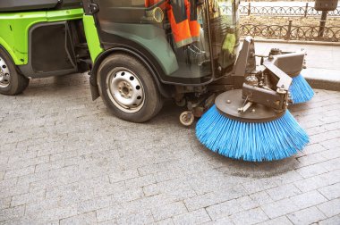 Şehir kaldırımlarını süpürmek ve yıkamak için yeşil belediye temizlik aracı. Parkta özel belediye ekipmanları, şehir sağlık hizmetleri ve çevre dostu teknoloji kavramı