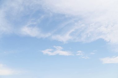 Yumuşak sirrus ve altokümülüs bulutları parlak mavi bir gökyüzüne dağıldı. Atmosferik hava koşulları, barışçıl bir arka plan ve güneşli bir bahar günü havası.