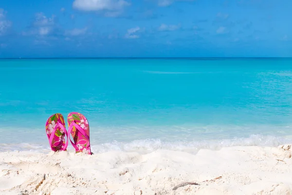 Pair of colored sandals on a white sand beach — Stock Photo, Image