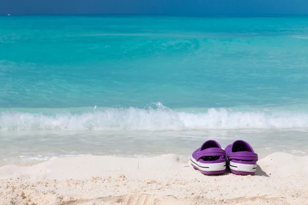 Par de sandalias de colores en una playa de arena blanca —  Fotos de Stock