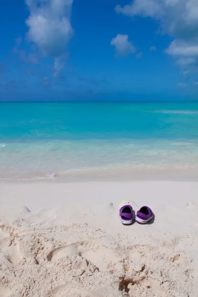 Paar farbige Sandalen an einem weißen Sandstrand — Stockfoto