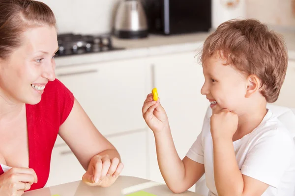 A young woman with a son having fun playing in clay — Stock Photo, Image