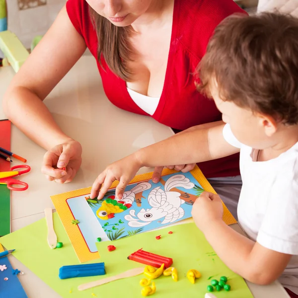 Una giovane donna con un figlio che si diverte giocando in argilla — Foto Stock