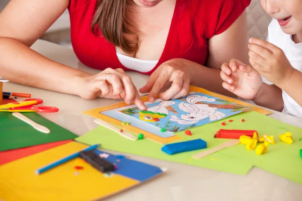 Una giovane donna con un figlio che si diverte giocando in argilla — Foto Stock