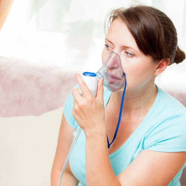 Młoda kobieta robi inhalacji z nebulizatora w domu — Zdjęcie stockowe