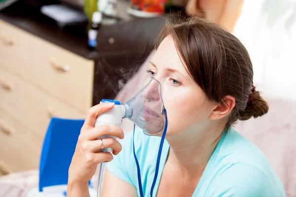 Junge Frau beim Inhalieren mit einem Vernebler zu Hause — Stockfoto