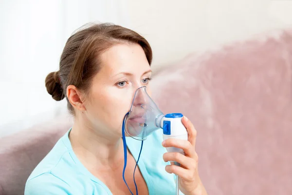 Mujer joven haciendo inhalación con un nebulizador en casa — Foto de Stock