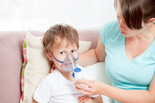 Genç kadın oğluyla evde bir Nebulizatör ile enhalasyon yapıyor