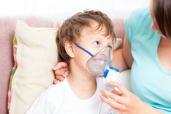 Jovem mulher com filho fazendo inalação com um nebulizador em casa — Fotografia de Stock